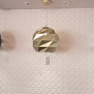 lavish_ Three geometric pendant lamps displayed against a textured wall in a Southport interior design setting.
