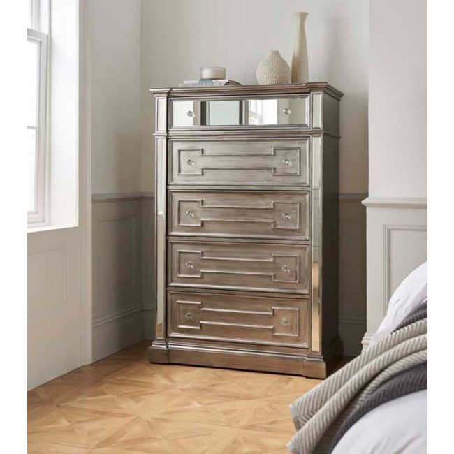 lavish_ A tall, mirrored Ophelia Tall Chest with five drawers, embodying Southport home decor, is situated in a room with parquet flooring.