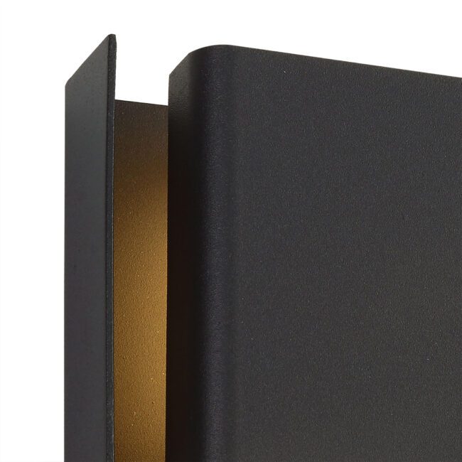 lavish_ Close-up of a textured black Oliver Wall Lamp surface with an angled edge revealing a gold interior.