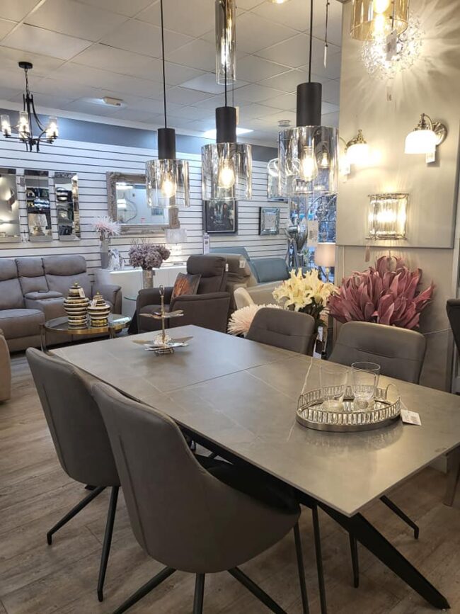 lavish_ A modern interior design display featuring elegant living and the Kore Extending Dining Table 1800-2300 with lighting fixtures in Southport.