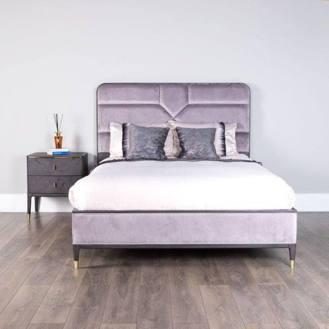 lavish_ Modern bedroom with a purple upholstered bed, a Diletta Bedside Table 2 Drawer - Ebony, and Southport-inspired home decor furniture.