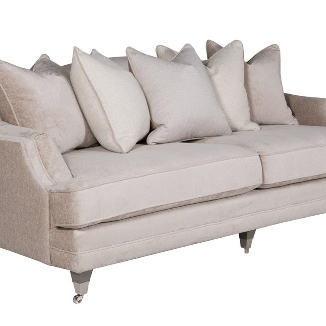 lavish_ Neutral-toned southport fabric sofa with plush cushions and dark wooden legs.