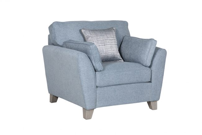 lavish_ A modern blue fabric armchair with cushions styled for Southport interior design, against a white background.