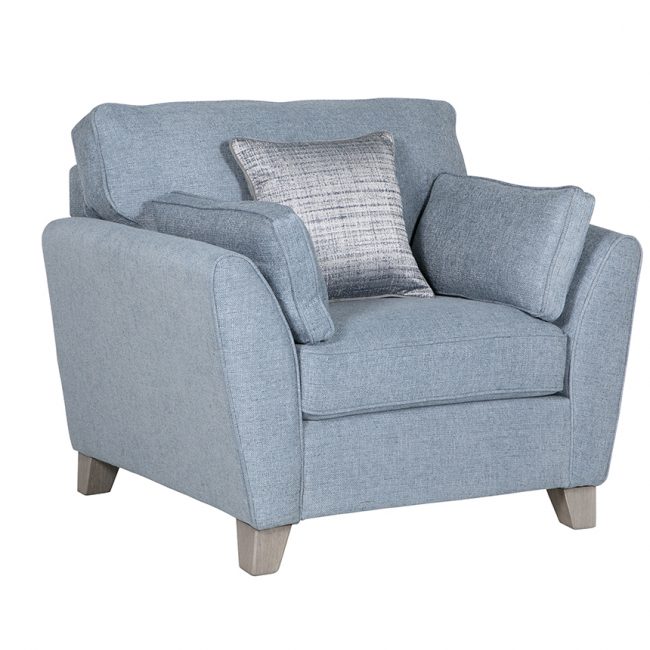 lavish_ A modern blue fabric armchair with cushions styled for Southport interior design, against a white background.