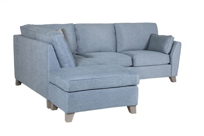 lavish_ Blue fabric sectional sofa with chaise and cushions, perfect for Southport interior design, on white background.