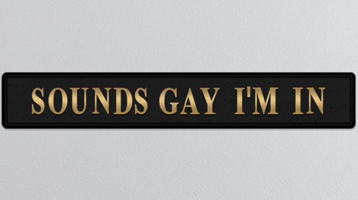 lavish_ BLACK SOUNDS GAY I'M IN GOLD FOILED SIGN against a textured gray background.